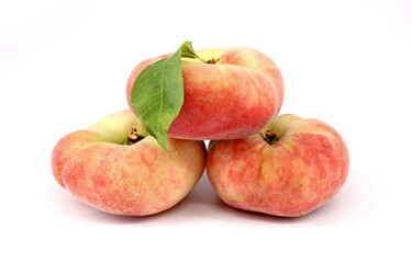 Flat peaches, known also as doughnut peaches, on white background
