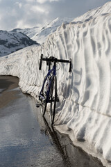 A Bicycle Leaning Against A Wall Of Snow In A Mountain Pass in San Gottardo, Uri, Switzerland