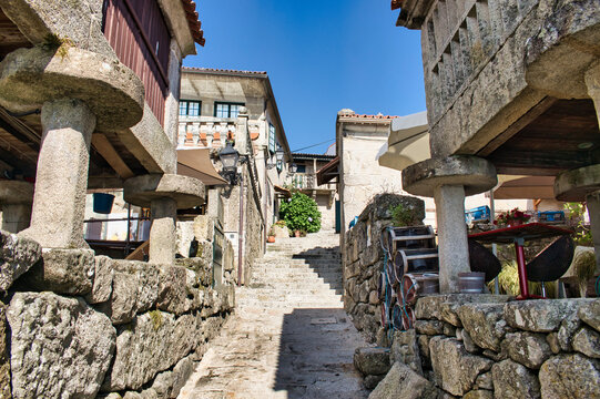 Estrecha calle peatonal con escaleras y tradicionales h&oacute;rreos gallegos elevados sobre pilares en la villa de Combarro, Espa&ntilde;a