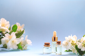 Tender jasmine flowers and oil. Small bottle with cosmetic (cleansing) aroma oil and white jasmine flowers. Natural skin care, homemade spa and beauty treatment recipe. Copy space.