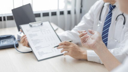 Male doctor made a diagnosis on a male patient and gave advice on treatment methods in the hospital examination room, Helping patients with medical advice, Health care counseling.