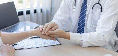 Male doctor specializing in psychiatrist comforts an anxious depression patient for medical treatment in a hospital diagnostic room, Medical treatment and health care concept.