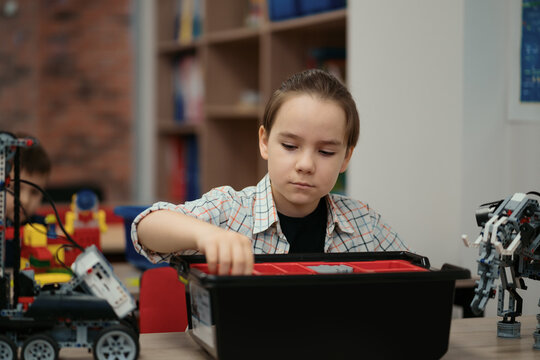 Boy Works on a Fully Functional Programable Robot for His School Robotics Club Project.