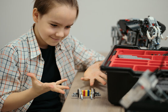 Boy Works on a Fully Functional Programable Robot for His School Robotics Club Project.