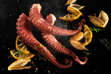 Whole fresh octopus tentacles sizzling on a grill