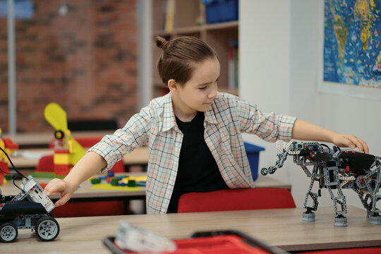Boy Works on a Fully Functional Programable Robot for His School Robotics Club Project.