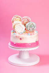 Birthday pink and white cake decorated with colorful meringue