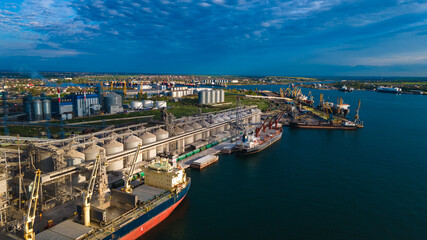 Fototapeta premium Industrial port in the field of import-export global business logistics and transportation, Loading and unloading container ships, cargo transportation from a bird's eye view.