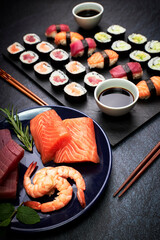 Close-up of fish sushi and vegetable sushi with chopsticks, soy sauce and a plate with ingredients. Oriental food