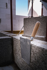 Mason trowel on a building block in a newly built house