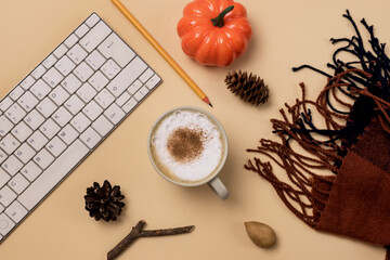 Workspace with Laptop or Keyboard Pencil Cozy and Warm Scarf Pumpkin Pine Cone and Cup of Coffee Autumn Stylish Office Desk Autumn Concept Flat Lay Yellow Background