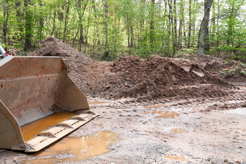 Wheel loader shovel on the ground in the forest