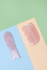 Gua Sha Massager on Color Block Background Pink Jade Stone for Face and Body Care Vertical Flat Lay Spa Minimal Concept