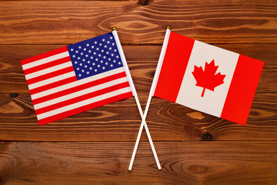 Flag of USA and flag of Canada crossed with each other. USA vs Canada. The image illustrates the relationship between countries. Photography for video news on TV and articles on the Internet and media