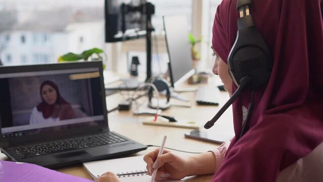 Muslim student video chats with teacher. Distance learning or Remote working during the lockdown period. Online Calling, Video Conferencing, Webinar, Chat