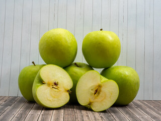 Green apples on a light wooden background.