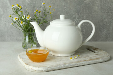 Concept of breakfast with chamomile tea on white textured table