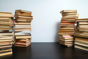 Big stack of books on the table. Studying before the exam. Pile of vintage books. Concept of education and studying