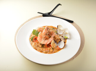 stir fried dry bee hoon mee noodle with mixed seafood lala shell and prawn in Thai tomyum spicy sauce asian halal menu