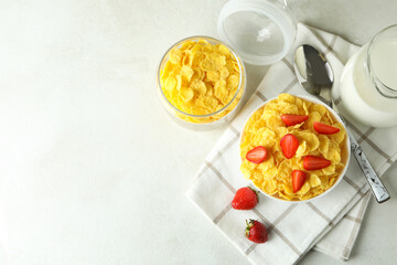 Concept of tasty breakfast with cornflakes on white textured table