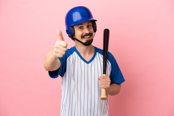 Young caucasian man playing baseball isolated on pink background with thumbs up because something good has happened