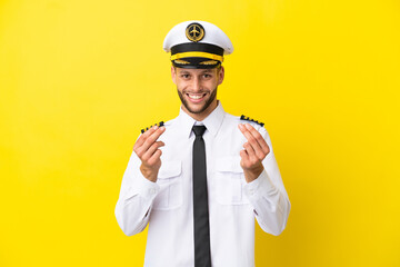 Airplane caucasian pilot isolated on yellow background making money gesture