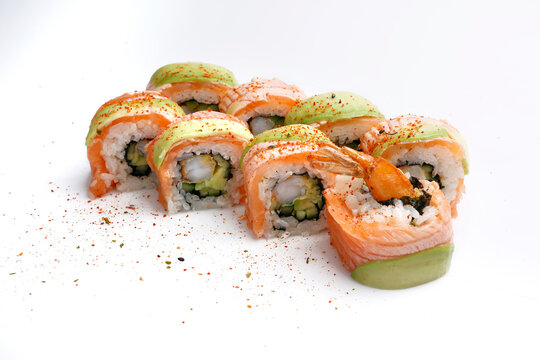 8 piece dragon roll set with shrimps in tempura, grilled salmon and avocado, garnished with spices, isolated on a white background, with a copy space. California sushi set. Japanese cuisine delicacy.