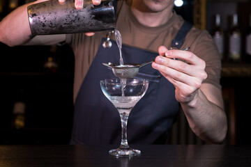 Close up hands of bartender making daiquiri cocktail