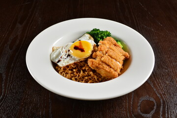 stir fried dry instant noodle mee indo in dark soya sauce with fried egg and crispy chicken chop asian halal menu