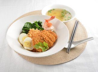 stir fried dry instant noodle mee indo in dark soya sauce with fried egg and crispy chicken chop and soup asian halal menu