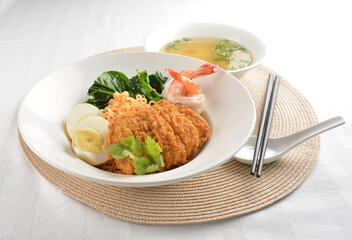 stir fried dry instant noodle mee indo in dark soya sauce with fried egg and crispy chicken chop and soup asian halal menu