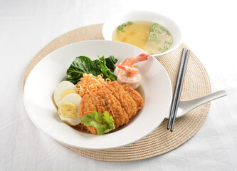 stir fried dry instant noodle mee indo in dark soya sauce with fried egg and crispy chicken chop and soup asian halal menu