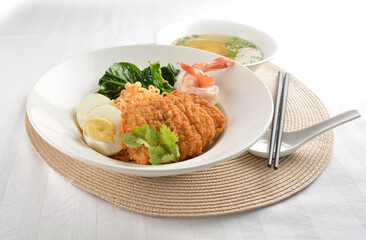 stir fried dry instant noodle mee indo in dark soya sauce with fried egg and crispy chicken chop and soup asian halal menu