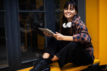 Fototapeta na wymiar Urban happy woman using digital tablet. Beautiful young woman having video call outdoors.