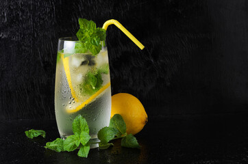 A glass of lemonade with a straw on a black textured background
