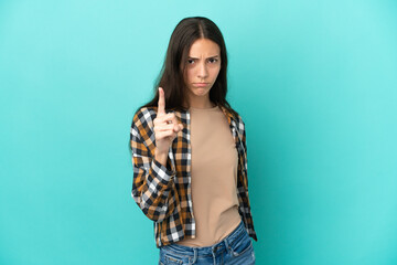 Young French woman isolated on blue background frustrated and pointing to the front