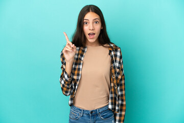 Young French woman isolated on blue background intending to realizes the solution while lifting a finger up