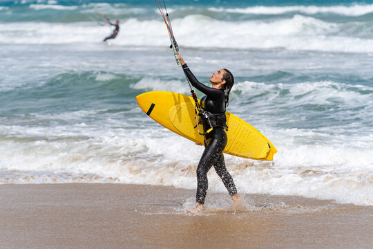 Kitesurfer with kiteboard on sea coast in stormy weather