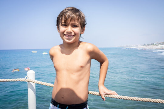 Little cute boy on sea pier enjoying vacation