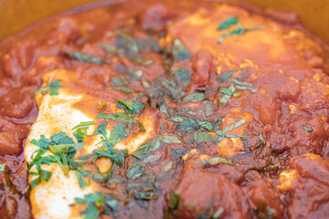 Obraz na płótnie Canvas Shakshouka - maghrebi dish with poached eggs in tomato sauce - close up