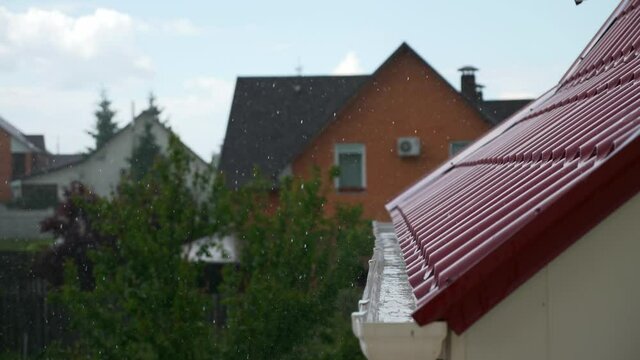 Rainwater Pouring on Gutter on Edge of Metal Roof. Heavy Rain Storm Water Drops Raindrops Fall on Drain Drainage System. Country Village Rural House Cottage. Overcast Sky Day. 2x Slow motion 60fps 4K