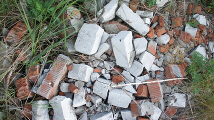 Construction waste. Heap of bricks in green grass