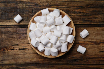 Delicious puffy marshmallows on wooden table, flat lay