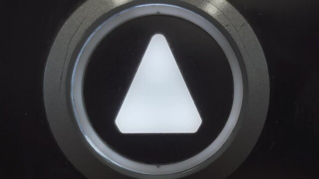 the finger presses the button with the image of an up arrow that lights up