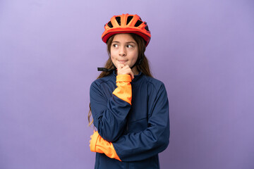 Little caucasian girl isolated on purple background having doubts and thinking