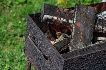 Ready for frying firewood is burning in a brazier. The preparation of cooking meat