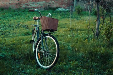 Fototapeta na wymiar Vintage black bicycle parking outdoor. Stylish bike with rustic basket.