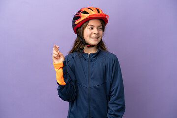 Little caucasian girl isolated on purple background with fingers crossing and wishing the best