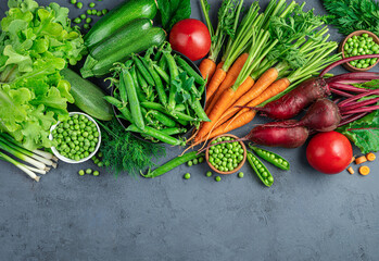 A variety of fresh, healthy vegetables and herbs on a blue background with space to copy. Top view.