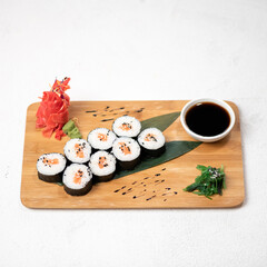  Japanese maki Sushi roll with rice and salmon on cutting board isolated on white background. Healthy Oriental food. Wellness concept. Top Side view. Soft focus. Copy space.